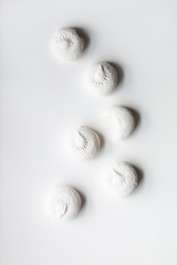 Six white sweet dessert zephyr marshmallows on white background with one bitten