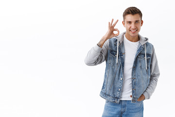 Handsome confident blond man guarantee perfect quality, show okay confirmation gesture, smiling...