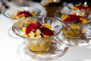 fresh fruit dessert jam poured on a white table,many desserts for the buffet,healthy vegetarian dessert with healthy fruits,fruit dessert for a healthy diet