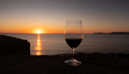 sunset at the ramparts of alghero city with silhouette with two glasses of prosecco