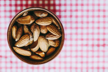 Amandes dans un bol en céramique avec fond carreaux rouge et blanc