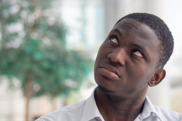 Fototapeta premium Upset African black man looking up; African black man looking with negative feeling, bad emotion, stress, problem