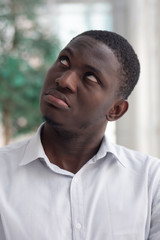 Fototapeta premium Upset African black man looking up; African black man looking with negative feeling, bad emotion, stress, problem