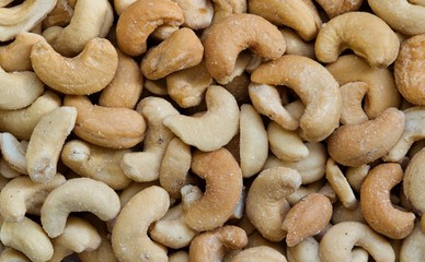 Cashew nuts, roasted and lightly salted. Macro image, full frame. Native to Brazil they are common as a snack and often used in Asian cuisine. They are high in carbohydrates, fats and vitamins.