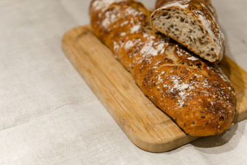 fresh bread on linen,bread lies on a cutting board,baked bread lies on the table,sliced ​​bread on linen background,home baked loaf,home made bread