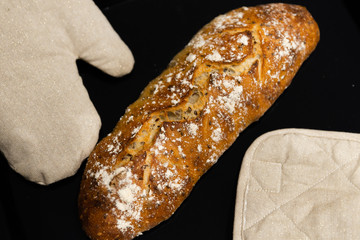 baked homemade bread on a black background,homemade fresh bread with seeds and flour,fresh baguette...