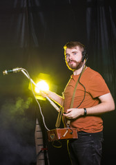 Radiation, pollution and danger concept - Man doing measures radioactivity on a dark background.
