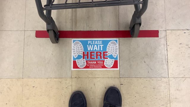 A view of a social distance sticker on the floor at the checkout line in a department store. Social distancing was a common practice to reduce the spread of COVID-19 during the pandemic of 2020.
