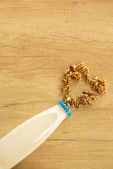 High angle view almond and milk in white bowl on  wooden textured background. Various vegan plant...