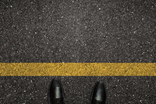 Businessman is looking down at his feet at the starting point. An image of a milestone roadmap is a representation of success in the future goal