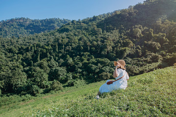 Fototapeta na wymiar Beautiful young woman looking at view of the mountains and forest. Vacation concept