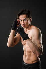 Fototapeta na wymiar Shirtless athlete posing in boxing gloves
