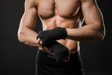 Fototapeta na wymiar Athletic muscular man torso with boxing gloves