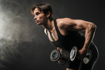 Fototapeta na wymiar Side view of muscular man holding weights