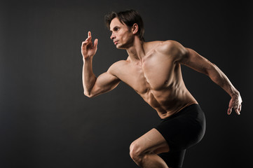 Obraz na płótnie Canvas Side view of shirtless muscular man posing