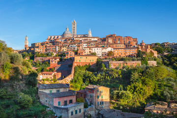 Fototapeta na wymiar Siena - historical medieval town at sunset with view of the Dome & Bell Tower of Siena Cathedral (Duomo di Siena), landmark Mangia Tower and Basilica of San Domenico,Italy