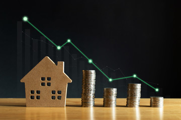 Coins money and house model with a graph of profit. Concept for property ladder, mortgage and real...