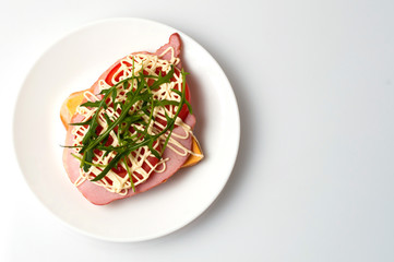 Sandwich of bread for toast, sturgeon, tomatoes, arugula, cheese and mayonnaise on a white plate in the view from the top flat lay, copy space