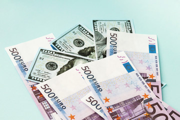 Obraz na płótnie Canvas A pile of money. 100 dollar and 500 Euro bills on a blue background. Money. Capital