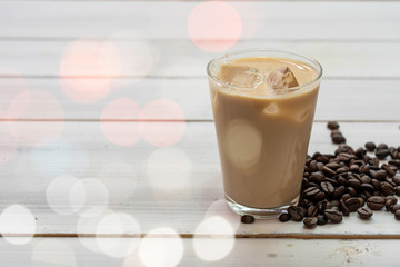 Ice coffee and coffee bean on white wooden.