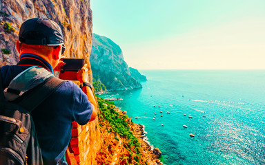 Man taking photos of Marina Piccola in Capri Island Italy reflex