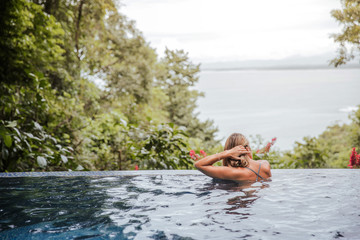 young woman relaxes in the pool at home during a relaxing bath looking calmly at the sea