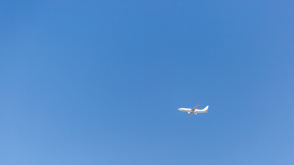 Fototapeta na wymiar The plane flies in the clear blue sky. Cloudless blue sky over which the plane flies.