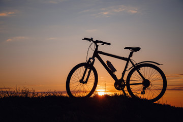 Naklejka na ściany i meble silhouette of a bicycle on the sunset sky