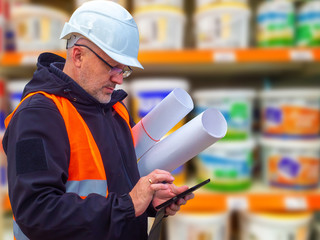 The Builder carries the boards. A man in an orange vest, constru