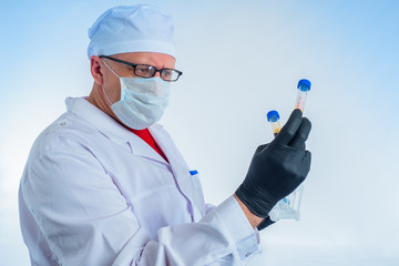 Doctor holds a strain of covid 19. Test tubes with coronavirus at the epidemiologist. Research...