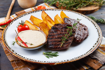 cooked steak and baked potatoes