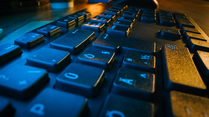 Fototapeta na wymiar Close-up Moving Macro Shotof the Computer Keyboard. Working, Writing Emails, Using Internet. Dark and Blue Colors