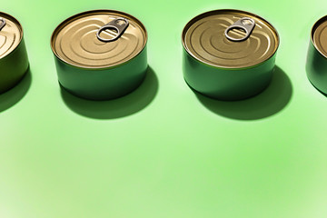 Cans of food against bright green background, with available copy space.