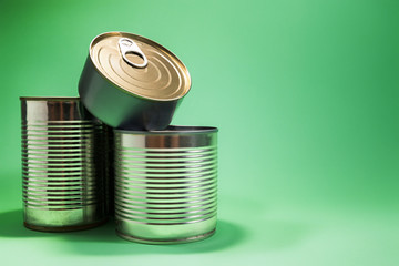 Various cans of food isolated against green background, with available copy space.