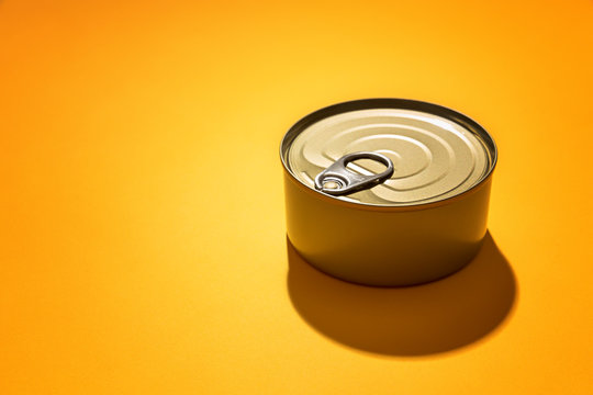 A can of food isolated against yellow background, with available copy space.