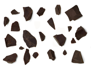 Cracked chocolates / broken chocolate chips or chocolate parts from top view isolated on white background