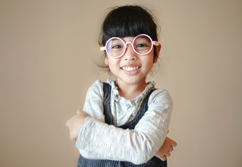 education, school and vision concept - smiling cute little child girl with eyeglasses.