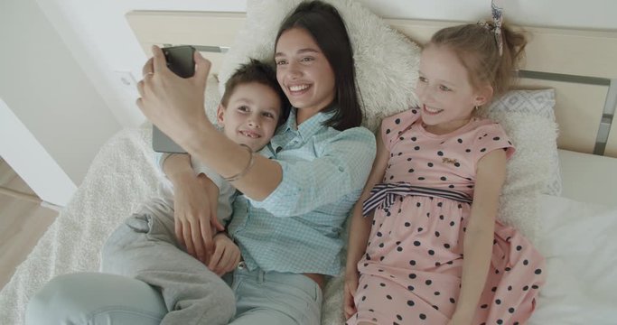 mother and children playing taking selfie