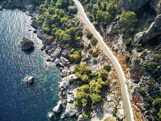 Fototapeta na wymiar Sharp stones and rocks in the turquoise, blue sea. Drone aerial shot from above with white stone coast. Turkey