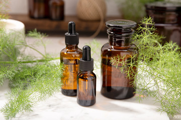 Fennel essential oil on amber bottles. Herbal oil for skin care, aromatherapy and natural medicine