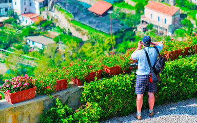 Man taking photos with camera in terrace in Ravello village reflex