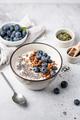 granola with yogurt, blueberries, chia seeds, pumpkin seeds on a light background. Breakfast
