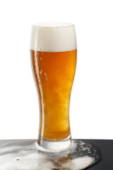 cold beer in glass with foam on white background