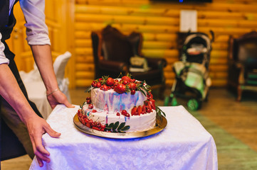 Cream wedding, decorated with strawberry and cherry fruit, cake at a party on a tray. Photography, concept.
