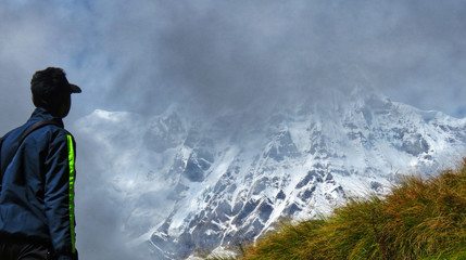 man looking at the snow mountain,man walking in the fog in annapurna base camp, nepal