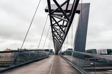 Fototapeta na wymiar Akrobaten pedestrian bridge over railroad in Oslo. Cloudy day of summer
