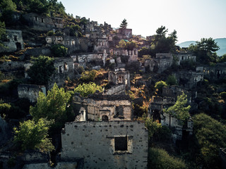 Fototapeta na wymiar Historical Lycian village of Kayakoy, Fethiye, Mugla, Turkey. Drone aerial shot from above of the Ghost Town Kayakoy. Greek Village. Evening moody warm sun of the ancient city of stone