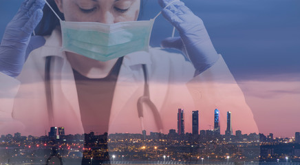 Double exposure of a doctor wearing a mask with the sky line in the background of the city of Madrid