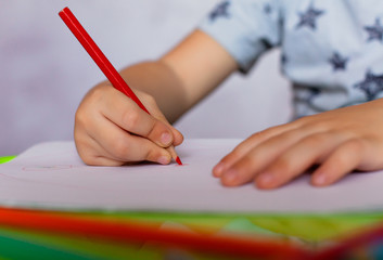 Close-up of childs hands drawing. Boy, drawing a picture for fathers day. Small boy draws at the table.