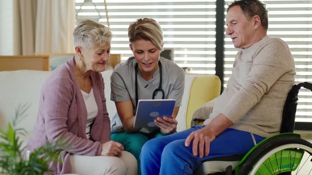 Healthcare worker visiting senior patient in wheelchair at home.
